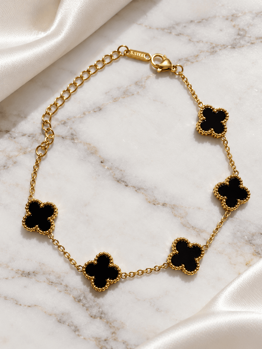 Black clover bracelet close-up on white marble