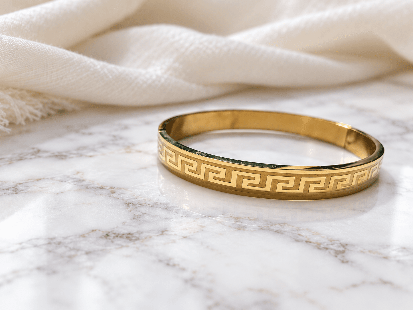 Greek key gold bangle kada on marble with ivory shawl