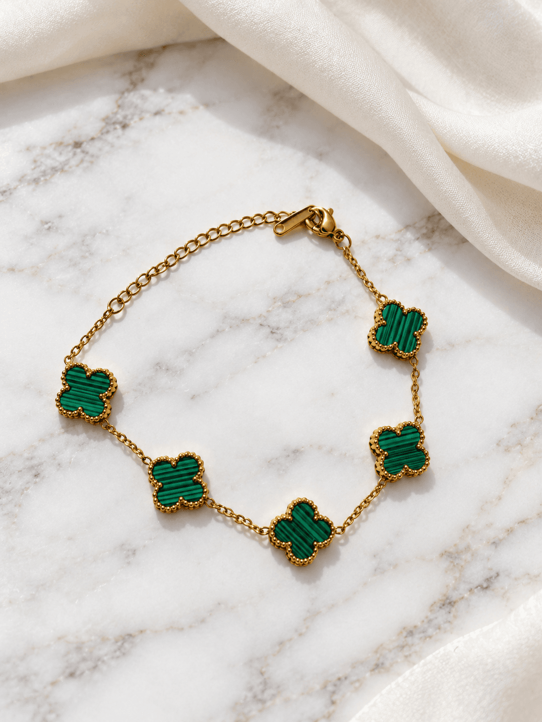 Green malachite clover bracelet on white marble